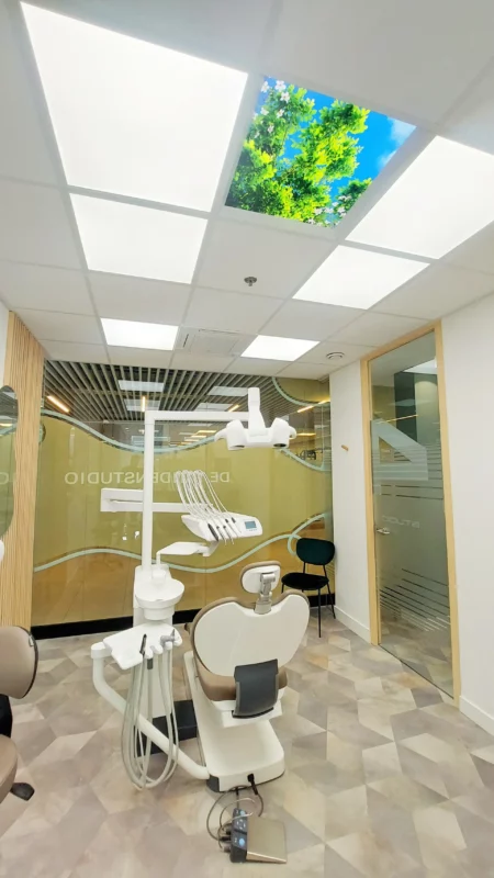 Modern dental treatment room at De Tandenstudio featuring DentLED daylight LED panels and calming ceiling photo panels.