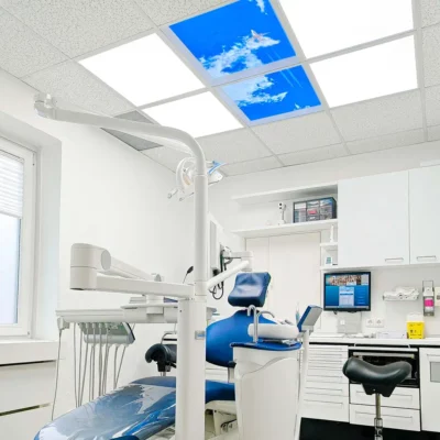 Modernized treatment room at Zahnarztpraxis Dr. Grünewald featuring Dentled photo ceiling panels with calming nature imagery and DL62 daylight LED lighting.