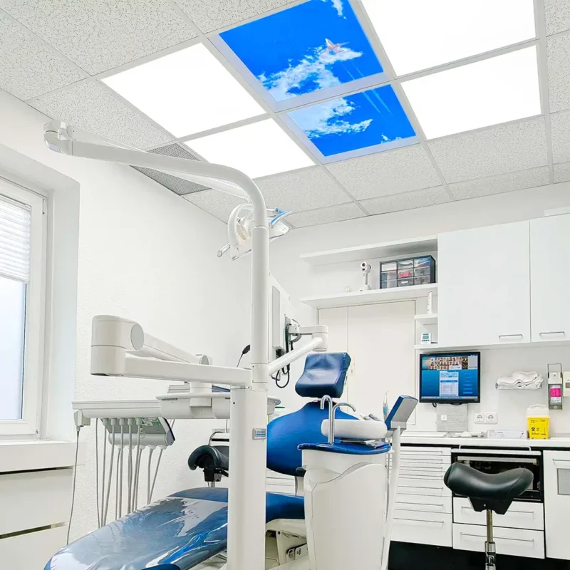 Modernized treatment room at Zahnarztpraxis Dr. Grünewald featuring Dentled photo ceiling panels with calming nature imagery and DL62 daylight LED lighting.