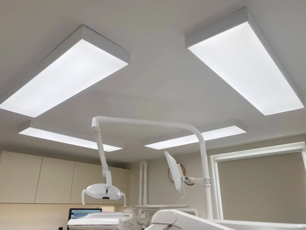 Four DentLED DL120 full-spectrum LED ceiling panels in surface-mounted frames around the dental chair at Priory Dental Care.